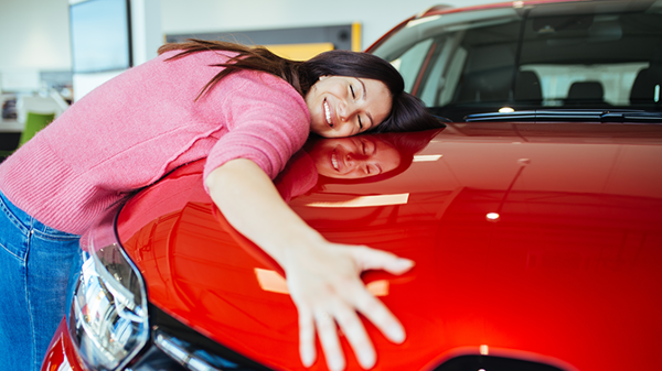 woman hugging her red car