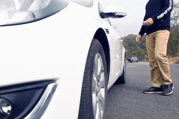 Animated clip of a man inspecting a white car, zoomed in on the front wheel and fender, highlighting the vulnerability of vehicle paint to bird droppings and environmental damage.