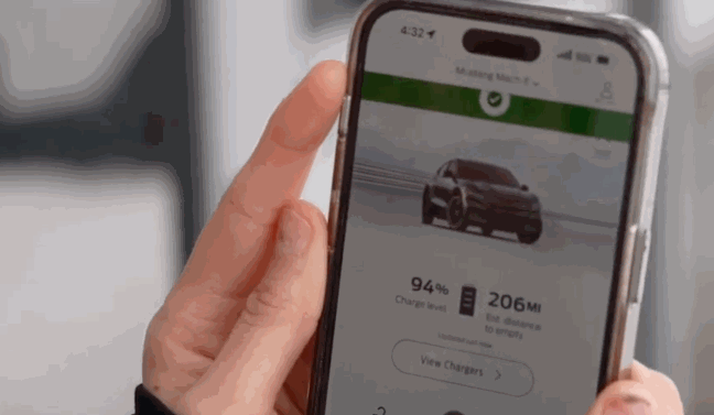Hand holding a smartphone showing a remote start app for a Mustang Mach-E, displaying 94% charge and 206 miles remaining.